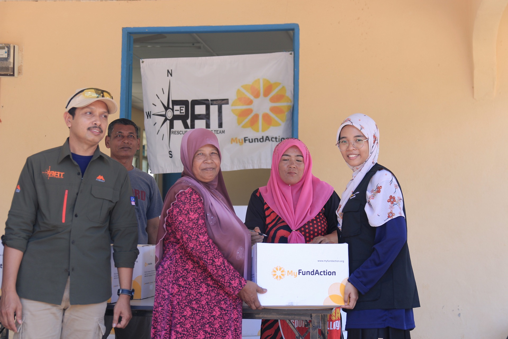 three women looking at the camera while holding a donation box from MyFundAction. This is one way to get donation tax deduction in Malaysia. 